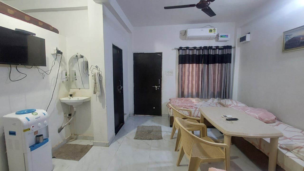 Living area at Madhav Homestay with seating, TV and dining table